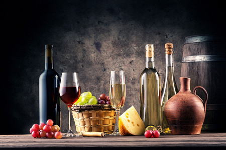发光的仍然以杯子瓶和桶砸在黑暗背景的葡萄酒为主题以杯子瓶和桶为主题的葡萄酒玻璃喝图片