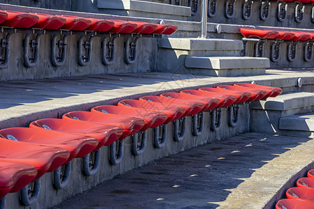 团体育场或两脚剧院台的空红色塑料椅子供观众用许多空座位在席上为观众使用许多空座位在近距离大厅为了图片