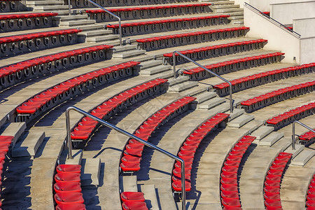 团体现代的育场或两脚剧院台的空红色塑料椅子供观众在座的许多空位上坐着圆形剧场图片