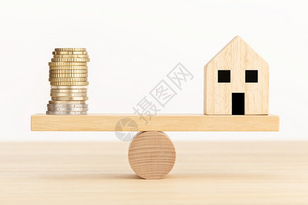 金融木制玩具房和锯上的硬币微型住房图片
