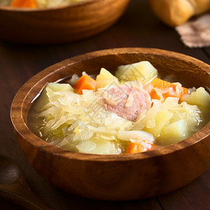 准备好的一顿饭土豆胡萝卜和小野火汤或炖菜配有土豆胡萝卜和wundworst在木碗中供餐用天然光拍照腌制图片