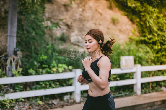成人快乐的亚裔女在公园路外露户游跑和慢人们图片