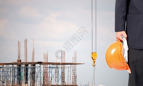 一种地点建设者工程师建筑和携带安全头盔的建筑师在正造的地区图片