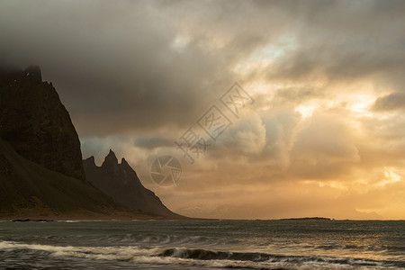 风景优美一种斯托克内日出时阴云笼罩的天亮威斯特拉霍山和海洋冰岛的维斯特拉霍山图片