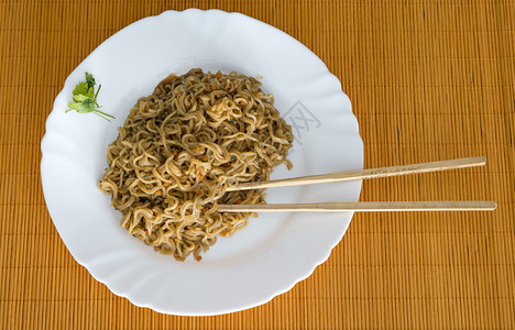 美味的碗餐桌上有竹棍的面条和牛肉在矩形盘中一顿饭图片