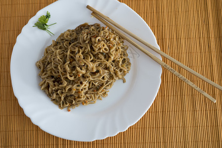 油炸食物餐桌上有竹棍的面条和牛肉在矩形盘中传统的图片