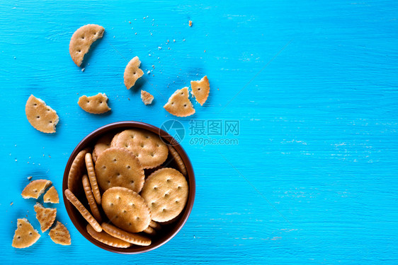从上方的蓝背景视图健康饮食的概念A碗蓝背景的脆饼和盘子B碗蓝背景的crepsy饼干顶视图面包小吃图片