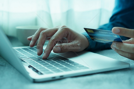 购物利用笔记本电脑和进行在线交易的男子使用笔记本电脑并进行网上交易在购买信用卡的人正在使笔记本电脑一种借贷图片