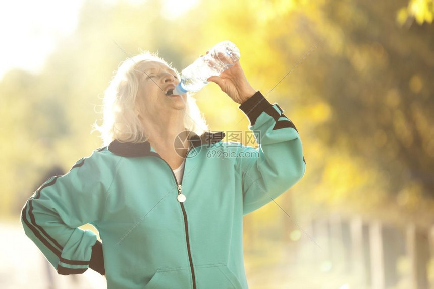 自然在明秋晚露天宴上慢跑出门后年长妇女饮用水阳光诺维科夫图片