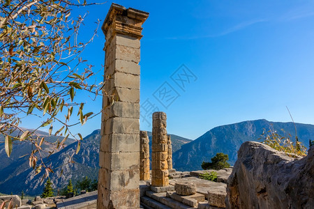 德尔福蓝色的自然阳光明媚山脉中希腊德尔菲古老废墟和山地背景上的蓝天空古迹图片