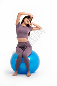 健康亚洲女在孤立的白色背景下坐在健身球上并做运动良好健康概念从锻炼开始移动美丽健身房图片