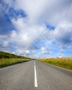 直的绿色宽一条空英语乡村道路和康沃尔的大天空图片