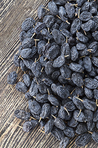 种子为葡萄干而燥的黑葡萄躺在木桌上干葡萄甜点黑色的图片