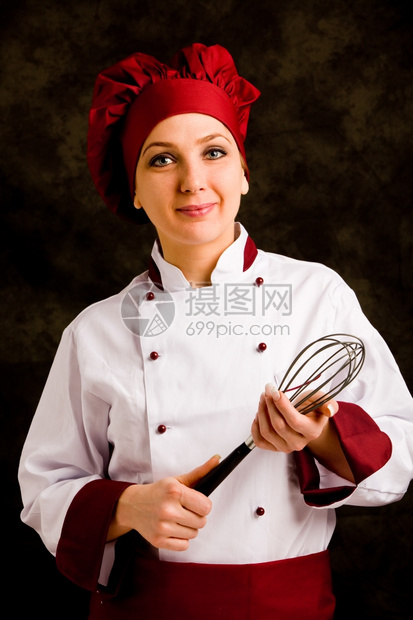 年轻成功女厨师手上抽鞭子的相片工具黑色准备图片