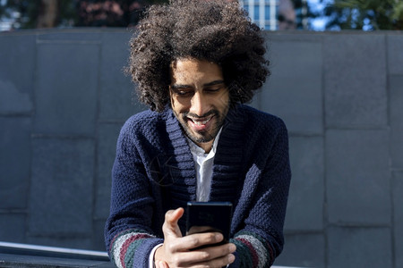 黑色的英俊Afro男子在街上使用手机的肖像成人时髦图片