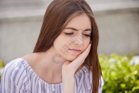 用手撑头的沮丧年轻女性图片