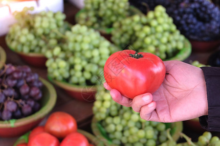 红色的在当地市场购买成熟番茄的妇女吸引人农场图片