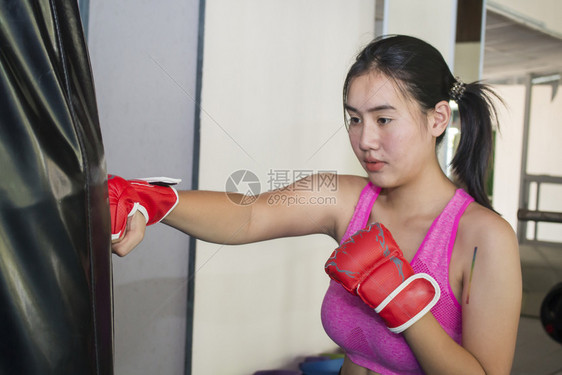 战斗机在体育馆参加拳击训练的年轻亚洲妇女武术图片
