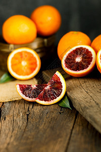 超过旧深色木质背景上的西里血橙片切圆圈健康图片
