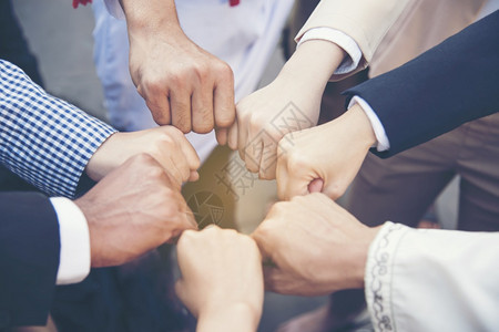商人合伙大学具有成功伴关系的多样化人群体和取得成功的伙伴关系一拳握手在办公室中显示力量和统一团队在伙伴合作概念中表现出企业团队合图片