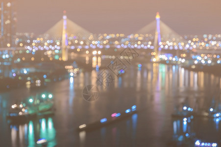 深夜照亮城市模糊的天空线bokeh灯光在河上反射黄色的街道发光图片