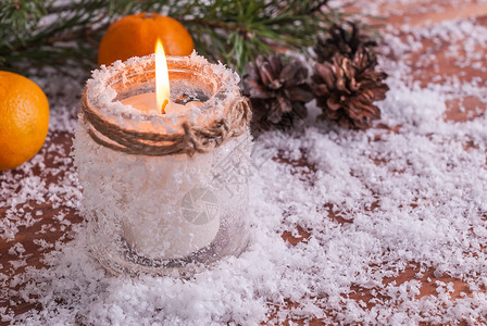 冷杉分支装饰风格新年配有燃烧的蜡烛橘子和木本底的fir树枝图片
