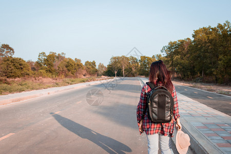 带背在沥青路农村地区行走的女旅妇外部步人们图片