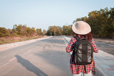 带背在沥青路农村地区行走的女旅妇成人游客假期图片