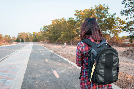 白种人微笑带背在沥青路农村地区行走的女旅妇美丽的图片