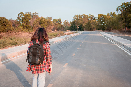 带背在沥青路农村地区行走的女旅妇背包微笑远足图片