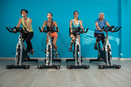 在健身中心骑自行车的四名妇女照片苗条闲暇工作室图片