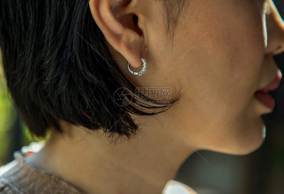 青年妇女戴漂亮银耳环的详情女饰品专注吸引人的年轻产品图片