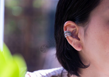 产品青年妇女戴漂亮银耳环的详情女饰品专注闪光吸引人的图片