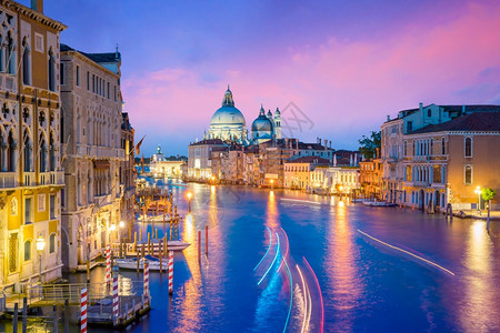 城市圣诞老人夜晚在意大利威尼斯的运河圣玛丽亚德拉萨卢特巴西利卡在黄昏时的背景中图片