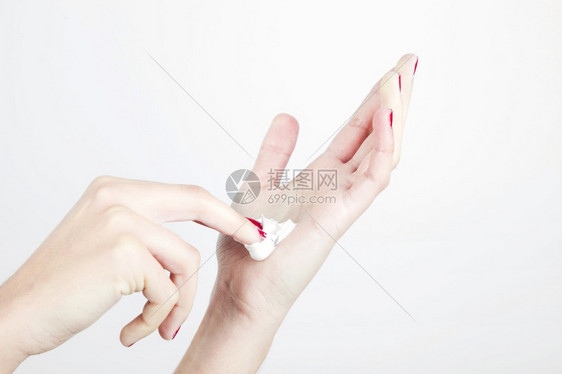 近身女手与湿润剂隔离的白色背景淑女新鲜的指甲图片