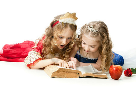 蓝色的两个美丽小女孩穿着长金发著红苹果和玫瑰的魔法书公主装饰着红色苹果和玫瑰季节服装图片