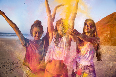 青少年在海滩上玩彩色粉末女孩们拉丁裔微笑图片