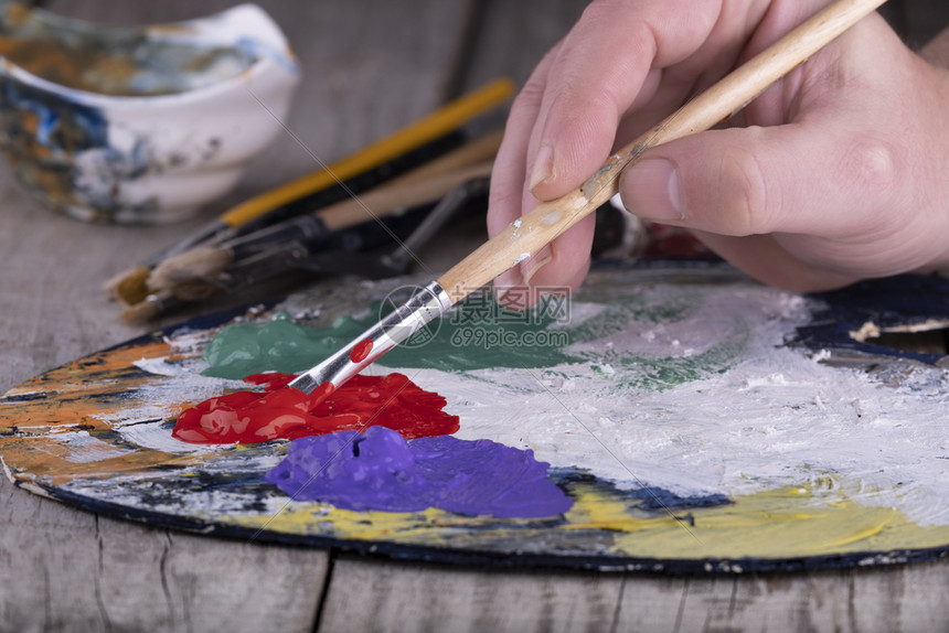 画美术学校关闭艺家手中涂有丙烯漆和油刷的木制调色板在职的教育图片
