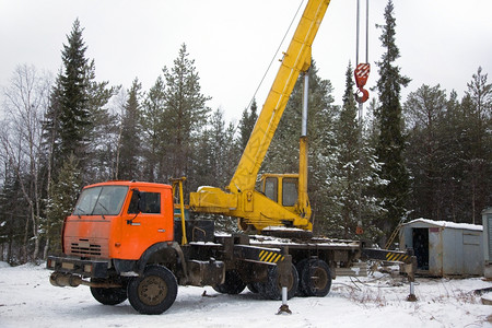 外展机械柴油冬季在树林里工作的起重机雪塔加图片