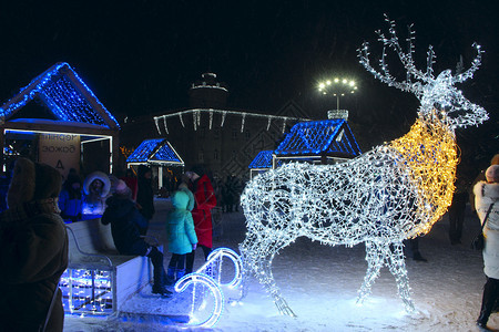 发光的人们在公园里用鹿形的节日圣诞花环在公园里休息数字喜庆的图片