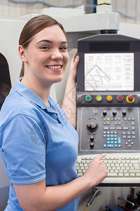 操作员女学徒工程师在厂操作CNC机器的肖像图制造业女图片