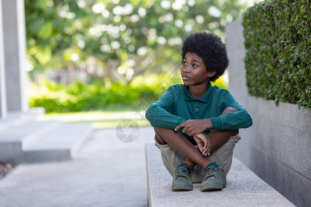 非裔美国人卷毛男孩在户外笑和看镜头自信的卷曲非洲裔图片素材