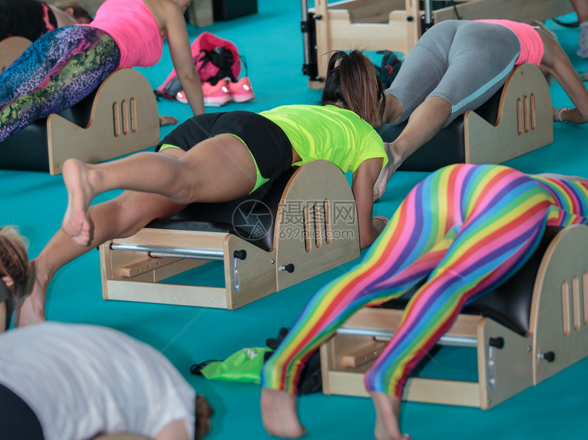 穿着运动服的女孩在健身房小木凳上做健身背部锻炼穿着运动服的女孩在健身房小木凳上做健身背部锻炼年轻的腹合身图片