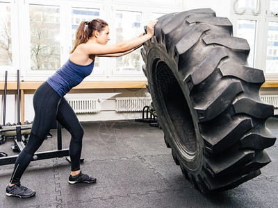 照片来自一位有吸引力的年轻女子在交叉体操A与拖拉机轮胎一起工作重量白种人健康图片