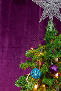 喜庆的预期玩具以紫色主题装饰圣诞树顶端有著名明星装饰吊挂球和蜡烛灯图片