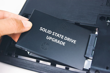 一名技术员在台膝上型计算机中安装了固态驱动器SSD空闲的坚硬数字图片