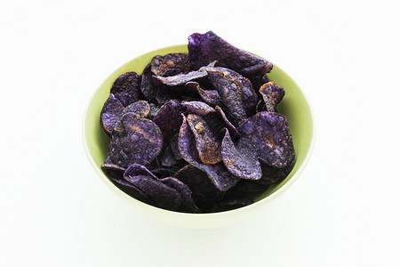 碗紫色的白背景紫土豆薯片堆油炸图片