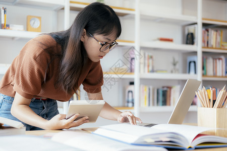 准备图书使用计算机和移动设备学习在线教育和学习的青年拼图生使用计算机和移动设备女士图片