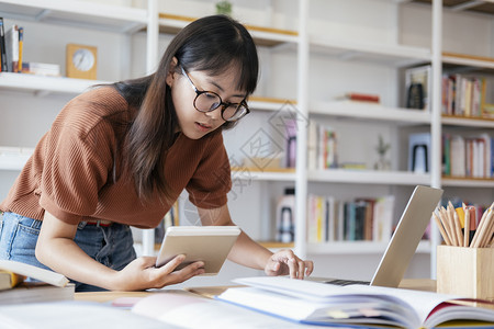 年轻的技术亚洲人使用计算机和移动设备学习在线教育和学习的青年拼图生使用计算机和移动设备图片