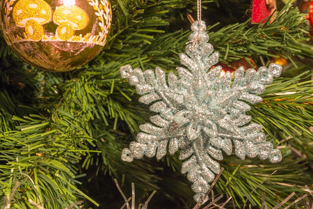 问候圣诞节绿色树上的亮银六点星装饰品图片